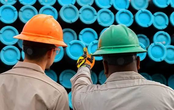 Two Workstrings workers pointing at pipes with blue tips