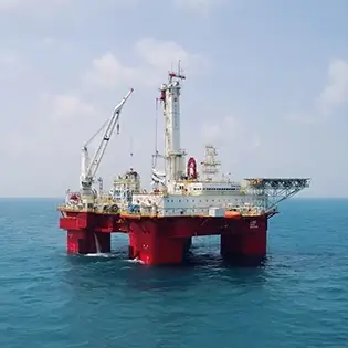 A red oil rig standing tall in the gulf of mexico