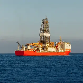 A large deep water with a drill tower attached to it